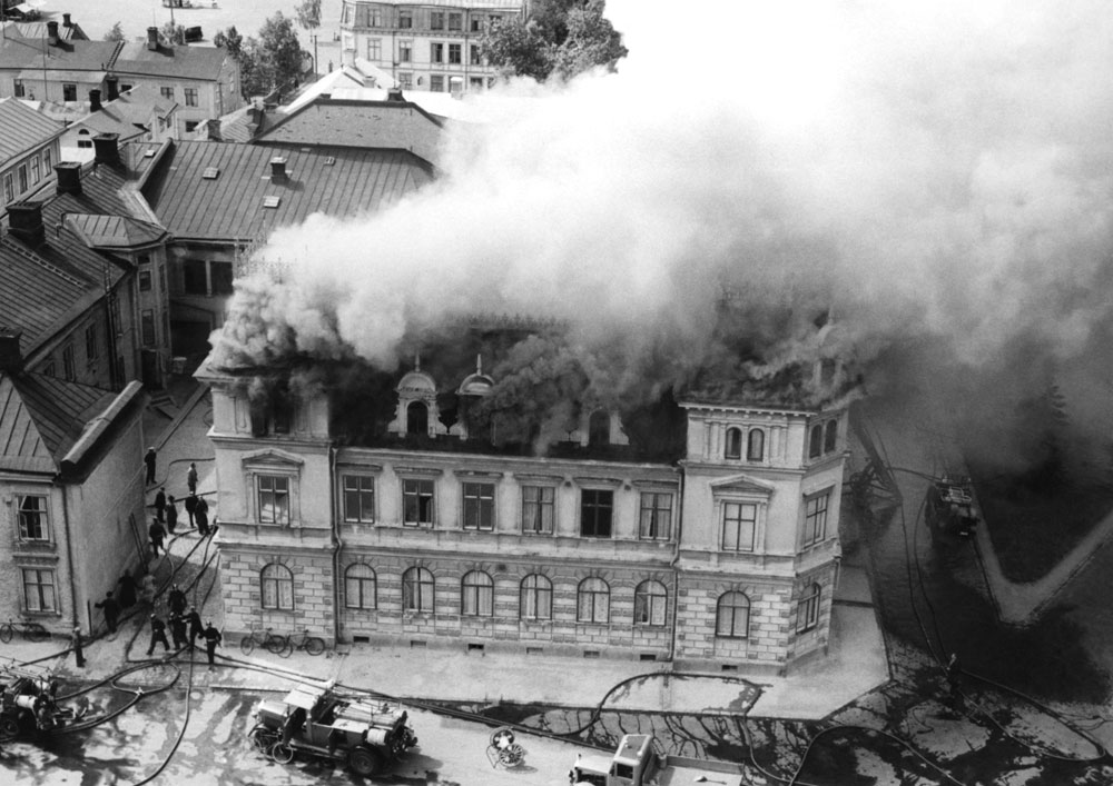 Foto taget uppifrån av hotell som det kommer brandrök ur.