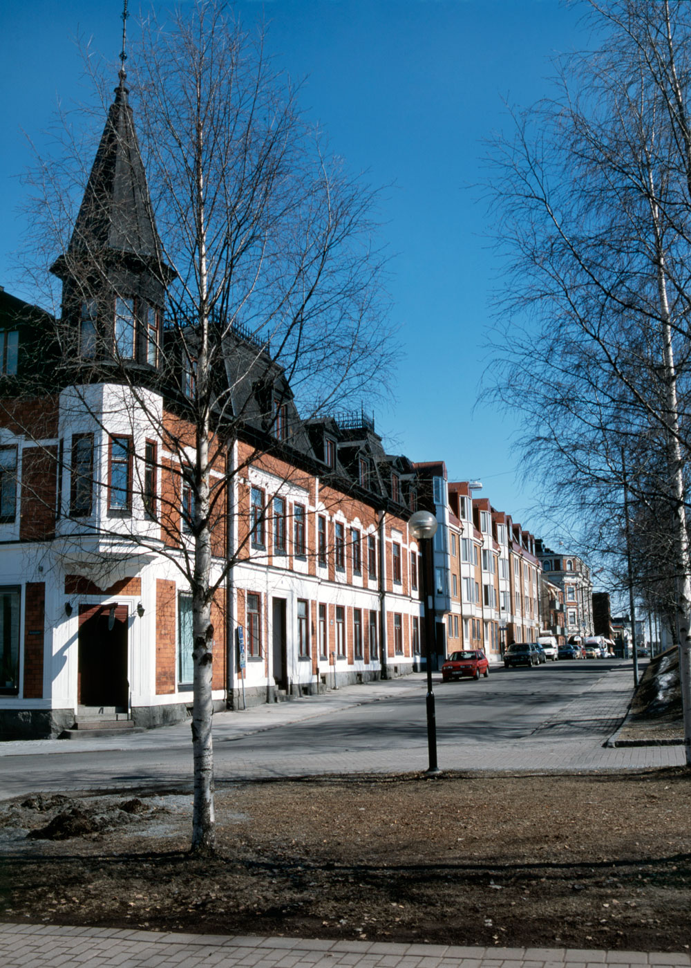 Hus med spetsigt hörntorn på stadsgata.