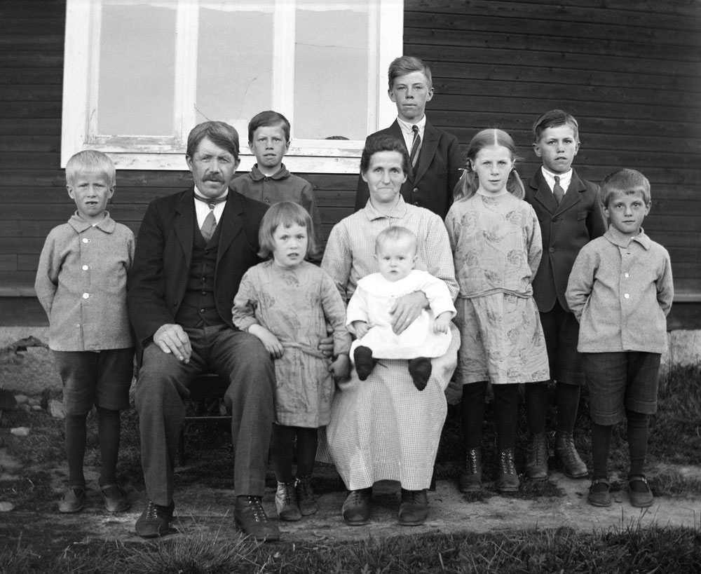 Gruppbild av kvinna och man med åtta barn.