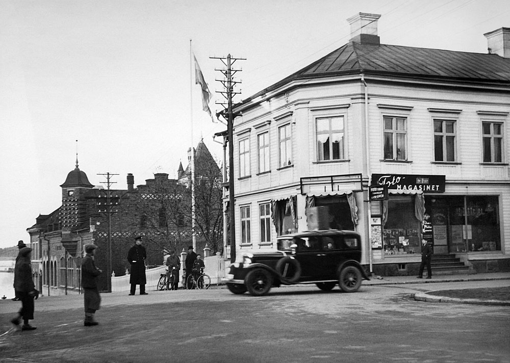Gatukorsning med svart bil av 1930-talsmodell.